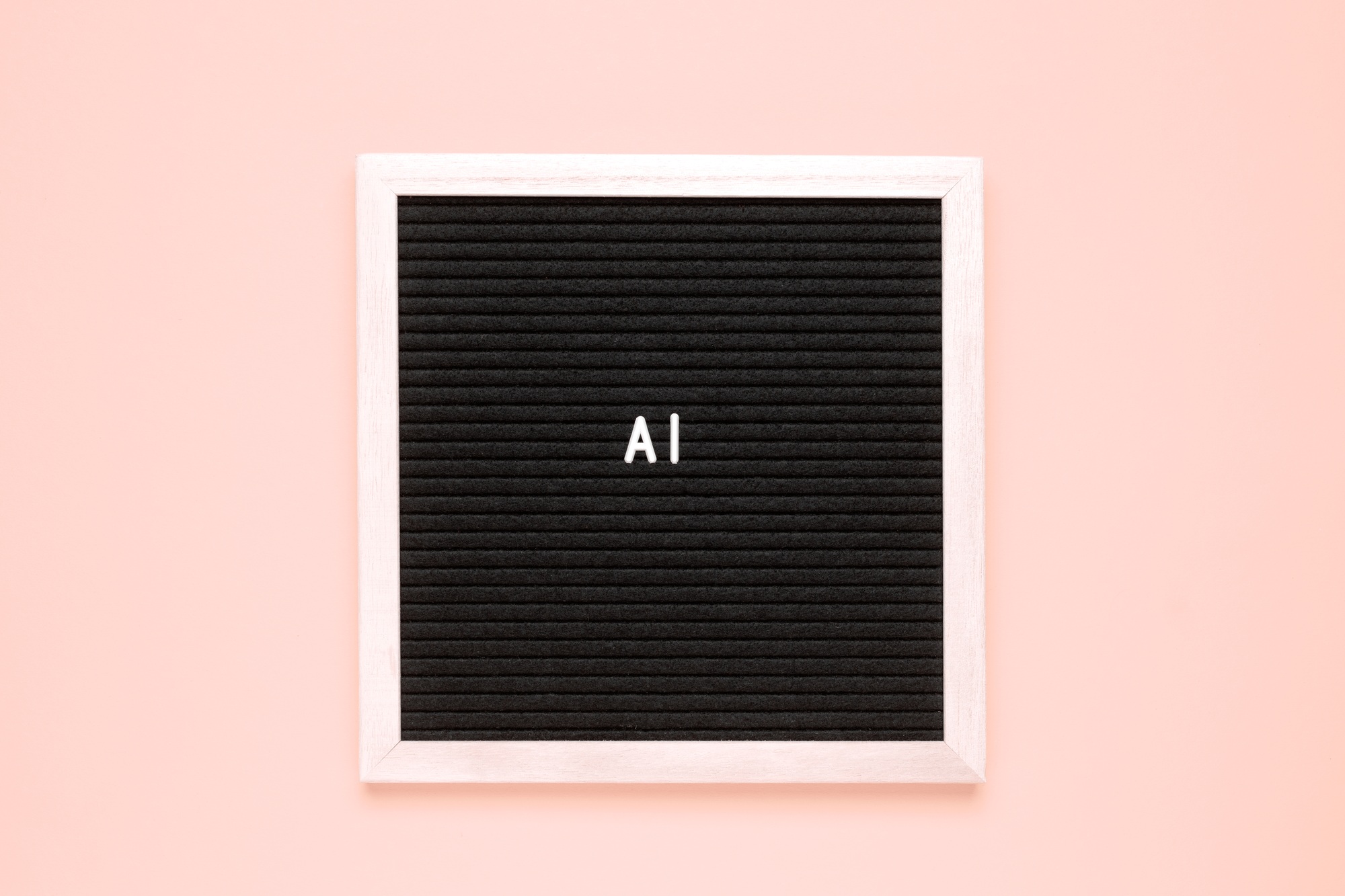 The word AI or Artificial Intelligence on black letter board over isolated beige background